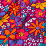 A close up of the print detail on the Frugi Elsie Organic Printed Cord Dress with a Retro Floral print design. This cord dress is a part of a wide range of organic cotton clothing for children available here at Babipur.