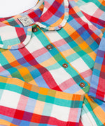 A close up of the collar and button closure on the front of the Frugi Rainbow Check Organic Cotton Ffion Dress. The dress has a rounded collar details and button closure on the front. This festive kids dress is a part of a wide range of organic cotton clothing for children available here at Babipur.