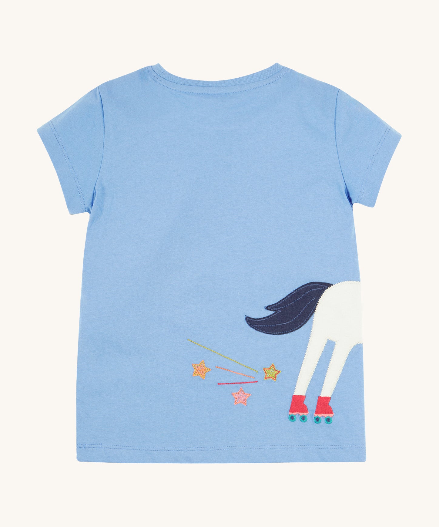 Back view of the Frugi Elise Wrap Around T-Shirt in cornflower blue – featuring the back of the white horse appliqué with roller skates and embroidered stars and trails. Made from GOTS organic cotton