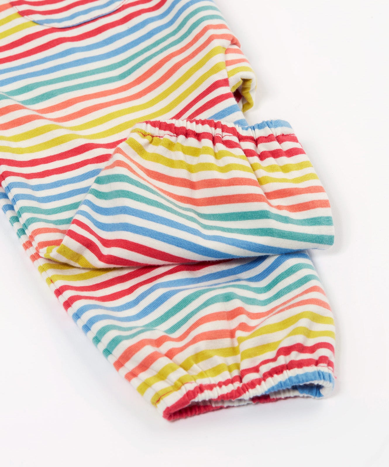 Close up of the Frugi kids cornflower rainbow stripe playsuit showing the short leg and elastic cuff detail on striped organic cotton fabric.