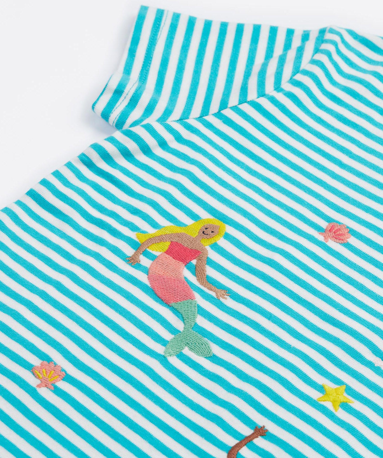 A close up of Frugi Ennis Embroidered T-Shirt in Moss Stripe's sleeve, featuring swimming Mermaids in the centre.