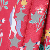 A close up of the shoulder strap on the Frugi rose unicorn floral explorer backpack showing the reflective stars detail.