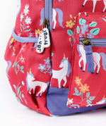 A close up of the Frugi rose unicorn floral explorer backpack showing the bottle holder, compartment zips and gentle white unicorn print detail