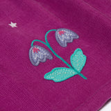 A close up of the flower details on the skirt of the Frugi Damson purple Flowers Organic Cotton Vali Corduroy children's Dress. This cord kids dress is a part of a wide range of organic cotton clothing for children available here at Babipur.