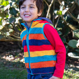 A child wearing the Frugi Autumn stripe inspired fleece gilet from the Autumn stripe/navy waterproof rambler 3 in 1 coat.   A thick warm fleece with light blue trim and a full length zip