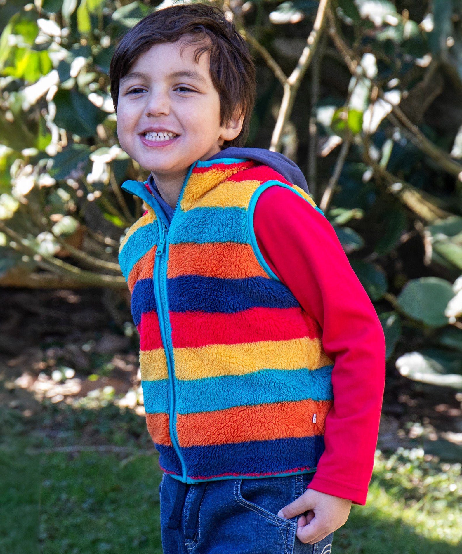 A child wearing the Frugi Autumn stripe inspired fleece gilet from the Autumn stripe/navy waterproof rambler 3 in 1 coat.   A thick warm fleece with light blue trim and a full length zip