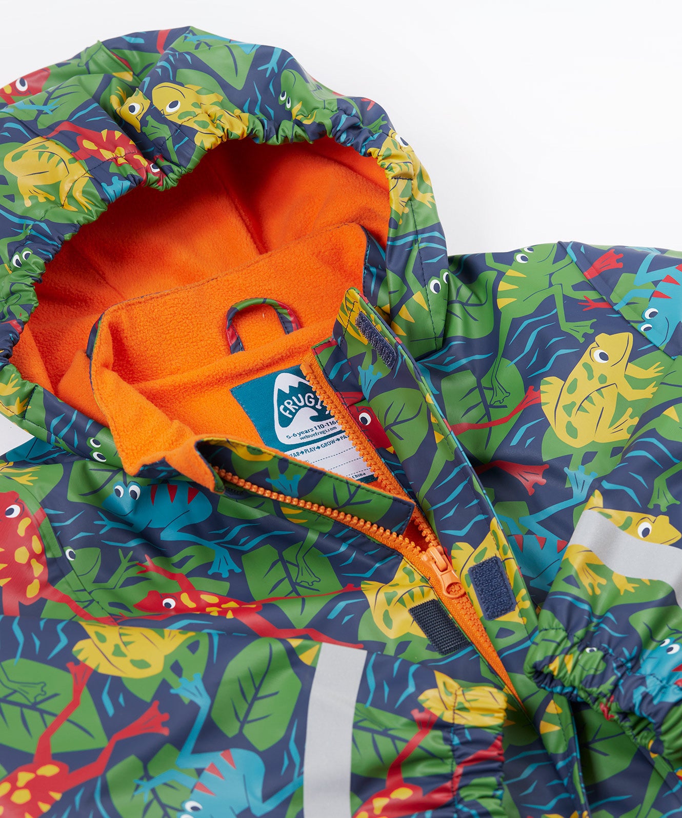 A close up of the Frugi kids be hoppy puddle buster coat showing the multicoloured frogs on navy waterproof material. Features a full length zip and velcro fasteners for a secure fit.