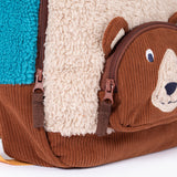 A close up of the  Frugi kids beary wild backpack. Showing the brown corduroy brown bear face pocket and zip detail.