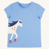 Frugi Elise Wrap Around T-Shirt in cornflower blue – GOTS organic cotton kids' t-shirt with short sleeves, featuring a playful appliqué of a white horse with roller skates that continues from the front to the back.