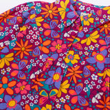 A close up of the button closure on the Frugi Elsie Organic Printed Cord Dress with a Retro Floral print design. This cord dress is a part of a wide range of organic cotton clothing for children available here at Babipur.