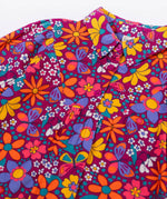 A close up of the button closure on the Frugi Elsie Organic Printed Cord Dress with a Retro Floral print design. This cord dress is a part of a wide range of organic cotton clothing for children available here at Babipur.