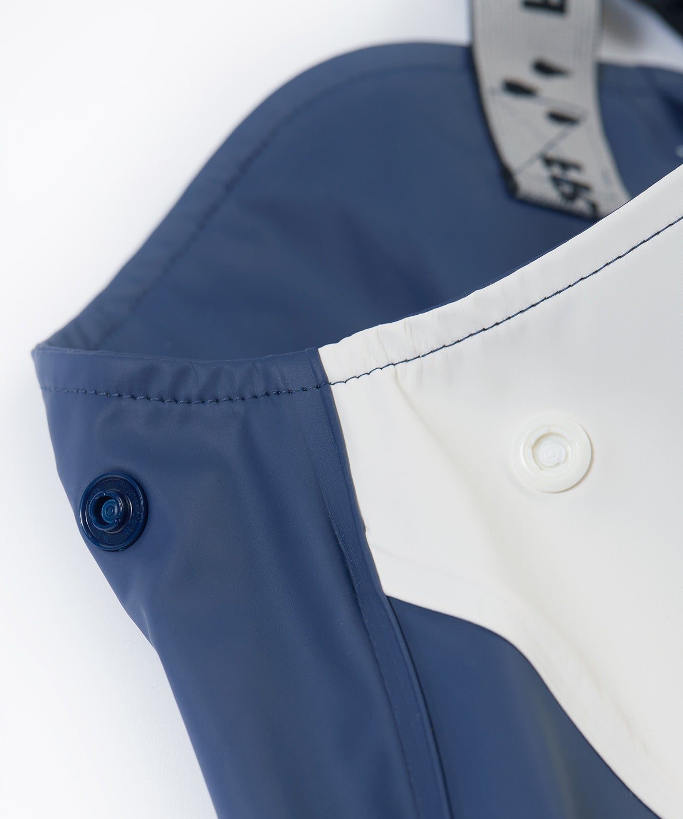 A close up of the popper detail located on the top side on the Frugi navy panda puddle buster waterproof trousers for a snug fit.
