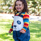 A child wearing the Frugi puddle buster trousers in navy / panda over a rainbow long sleeve top. A waterproof trouser with shoulder straps for a secure fit.