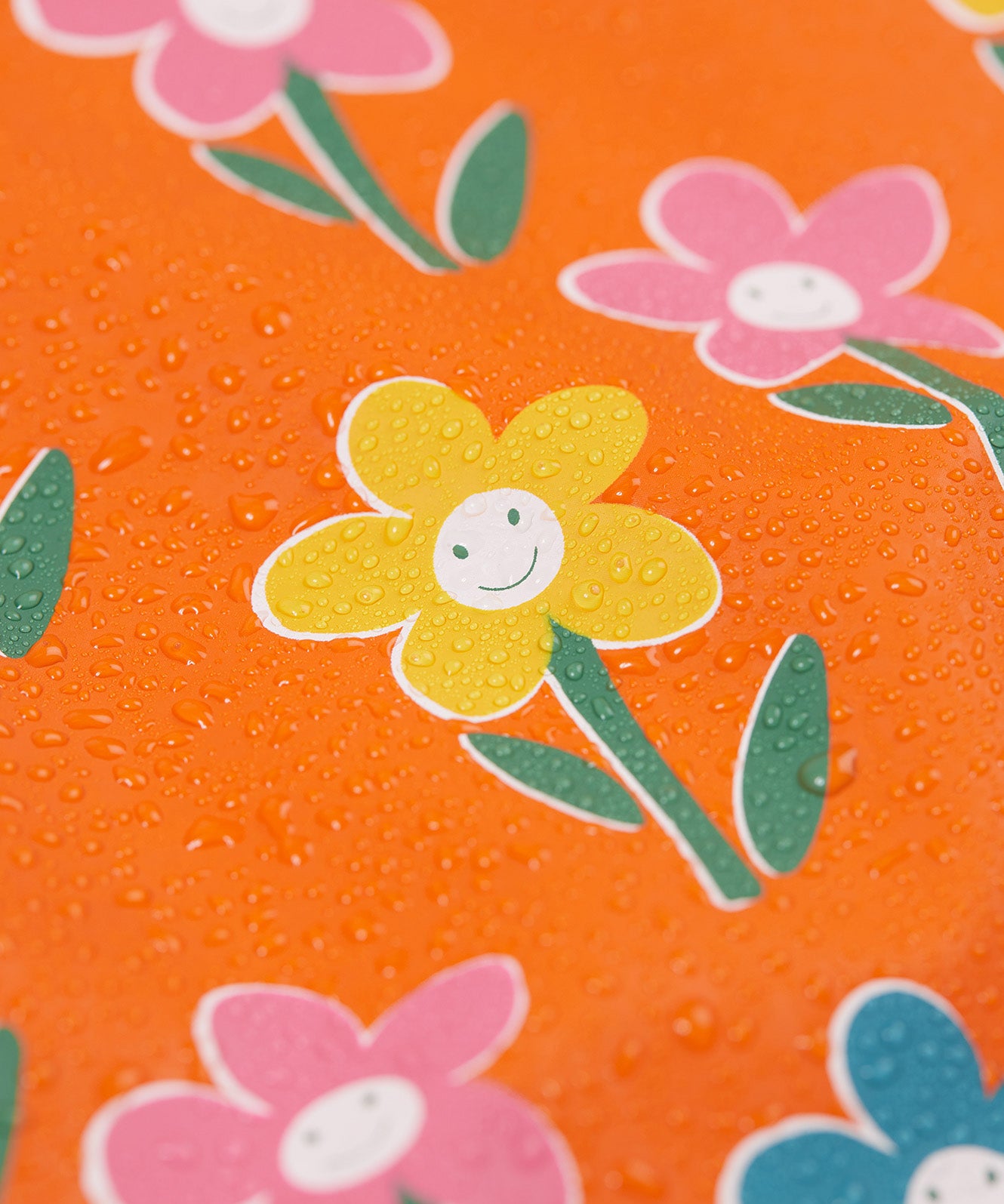 A close up of water on the Frugi puddle buster fun flowers coat showing the waterproof feature