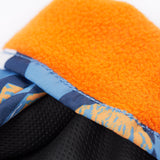 A close up of the Frugi kids penguin waddle snow mittens showing the black grippy palm and orange fleece inner for warmth