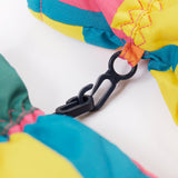 A close up of the Frugi kids rainbow check snow mittens showing the black clip detail on each mitten that can be attached on a ski coat.