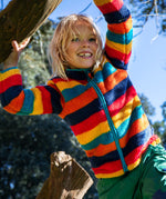 A child wearing the Frugi Autumn stripe ted fleece. A long sleeve striped thick fleece with light blue trim and turn up collar.