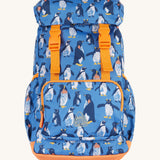 Frugi kids trail blazing backpack in penguin waddle. A blue outdoor backpack with orange trim and multiple penguin prints. Features a flip top main compartment and zipped compartment in the front with 2 bottle holders.