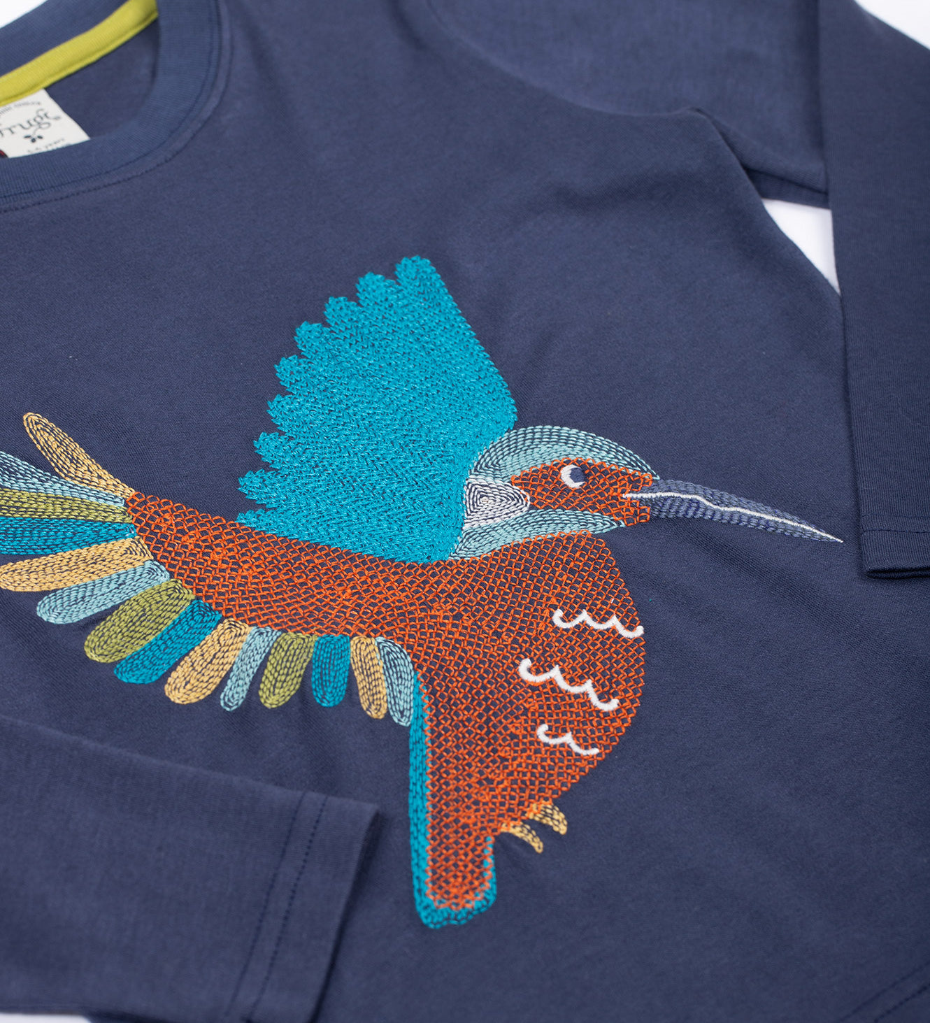 A close up of the embroidery on the front of the Frugi navy kingfisher Organic Cotton Embroidered long sleeve children's Top. This top is a part of a wide range of organic cotton clothing for children available here at Babipur.