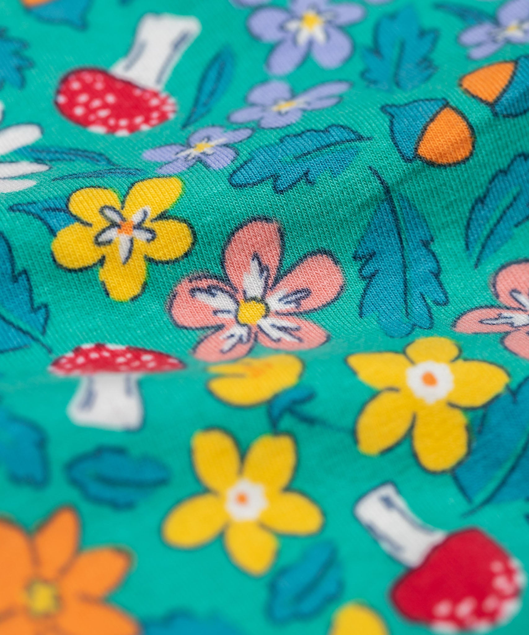 A close up of the Frugi kids kyla outfit in tulip/wild woods showing the woodland theme print detail on the turquoise bottoms