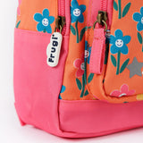 A close up of the bottom of the Frugi little adventures fun flowers backpack showing the zip detail and pink trim.