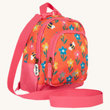 Side view of the Frugi little adventures fun flowers backpack showing the zip detail and handy pink rein that's clipped to the top of the bag.