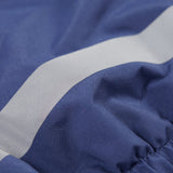 A close up of the reflective strap on the Frugi little kids navy waterproof dungarees.