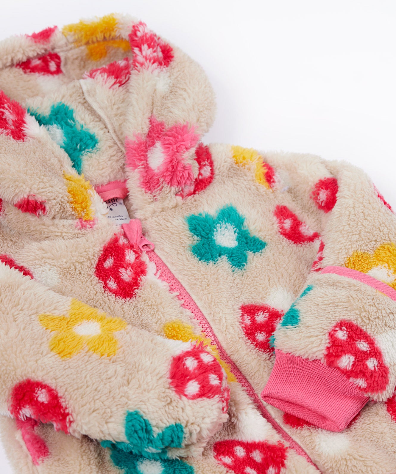 A close up o the Frugi kids recycled cosy snuggle suit in mushroom fields showing the pink zip detail and matching pink cuff on thick warm recycled textile fabric.