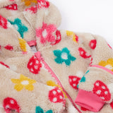 A close up o the Frugi kids recycled cosy snuggle suit in mushroom fields showing the pink zip detail and matching pink cuff on thick warm recycled textile fabric.