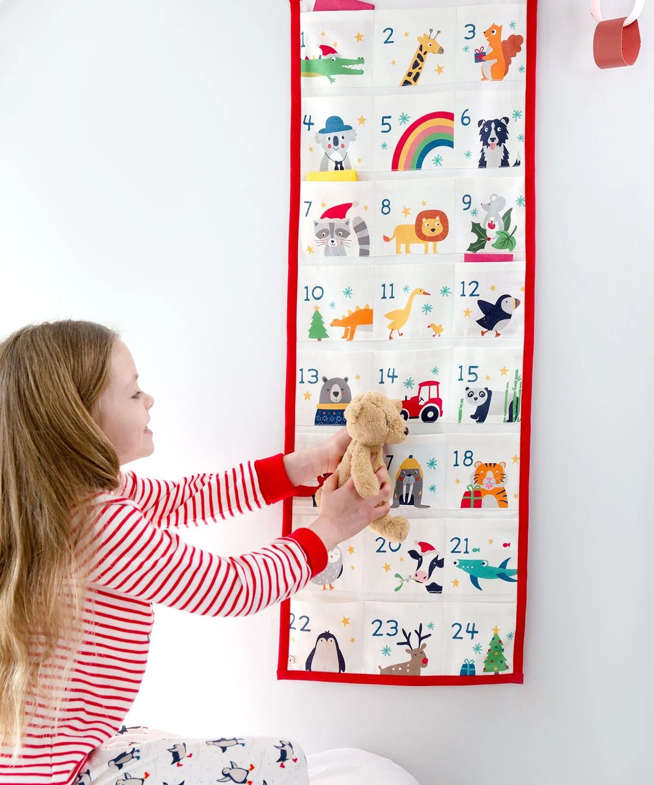 A little girl looking at her Frugi Organic cotton Christmas advent calendar, full of iconic Frugi Characters