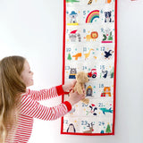 A little girl looking at her Frugi Organic cotton Christmas advent calendar, full of iconic Frugi Characters