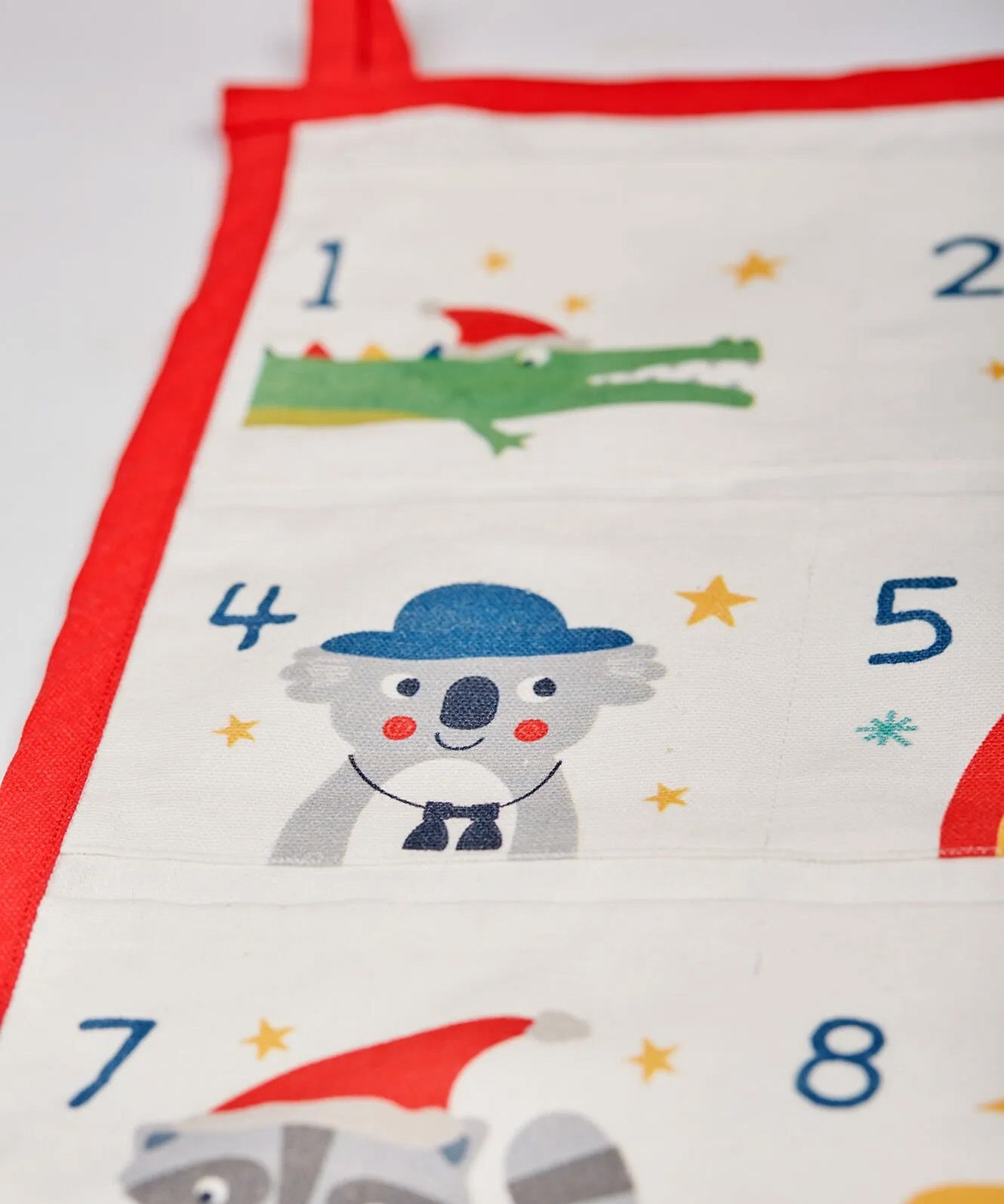 A closeup of The Frugi Organic cotton Christmas advent calendar, showing day 4 pouch with a cute koala illustration in Frugi's iconic style
