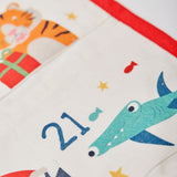 A closeup of The Frugi Organic cotton Christmas advent calendar, showing pouch for day 21 with a hammerhead shark illustration.