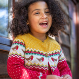 A child wearing the Frugi Festive Fair Isle Organic Cotton Kids' Carol Cardigan featuring red, yellow and green patterns and robin redbreast details. 
This knitted cardigan is a part of a wide range of organic cotton clothing for children available here at Babipur.