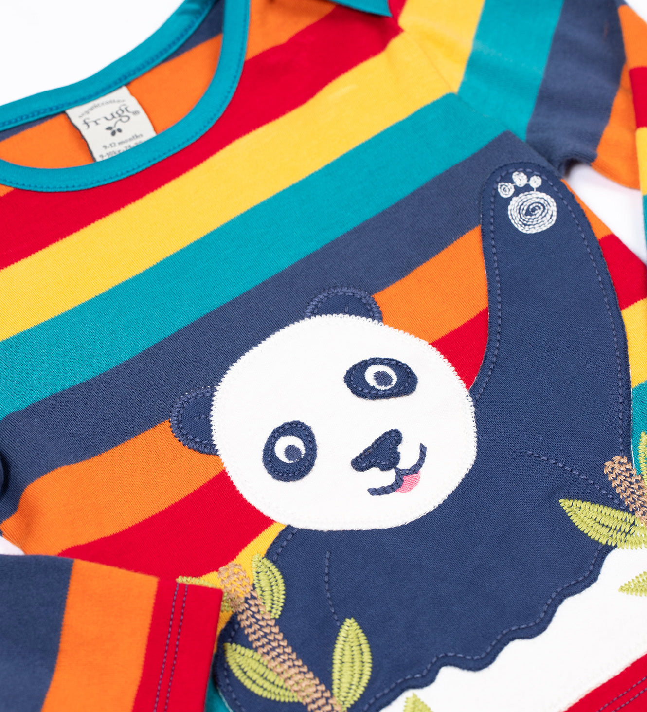A close up pf the applique detail on the front of the Frugi Children's Bobby panda Applique rainbow striped Organic Cotton long sleeved Top. This children's top is part of a wide range of organic cotton clothing available here at Babipur.