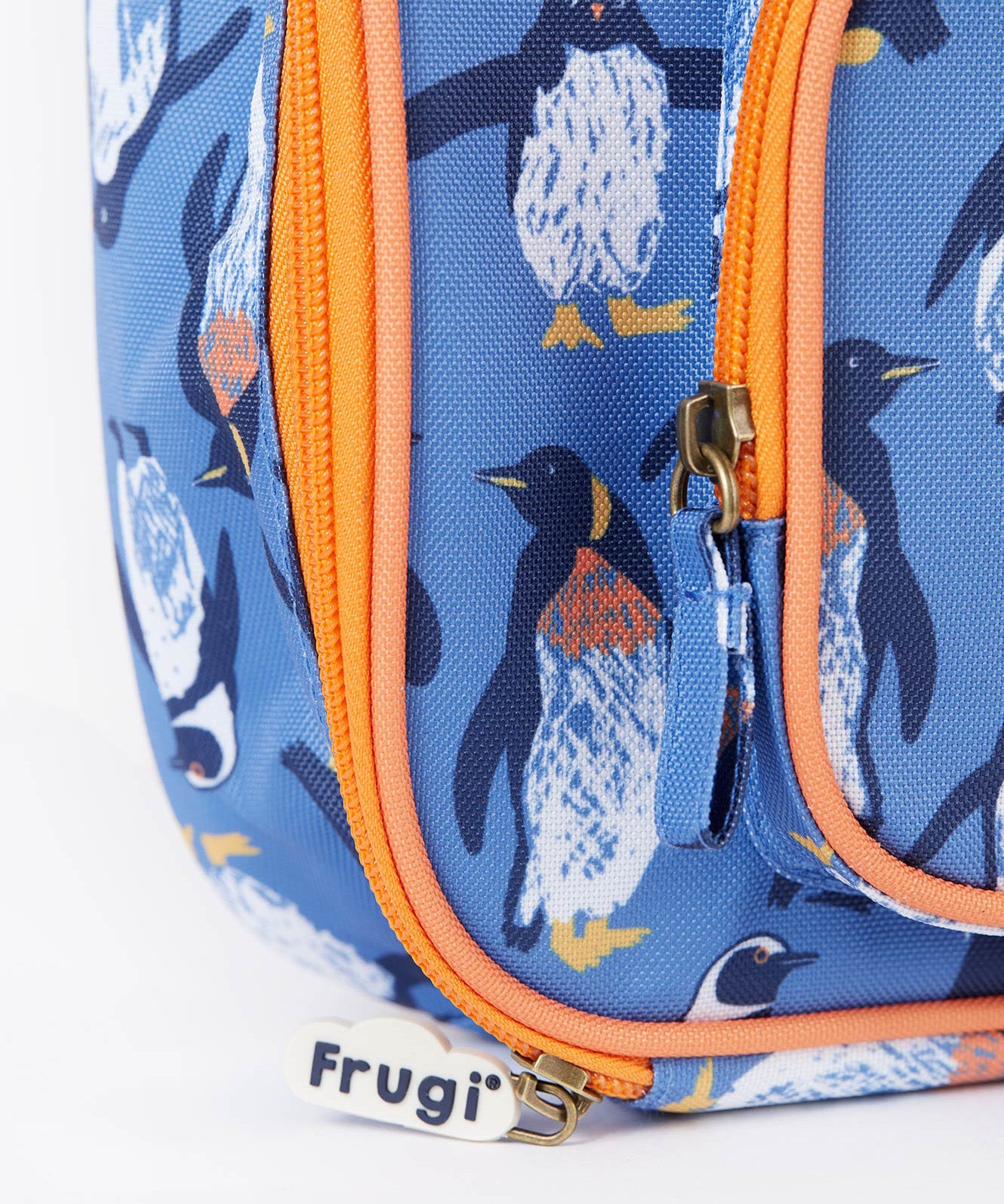 A close up of the Frugi kids pack a lunch bag in penguin waddle. Showing the orange trim and zip detail