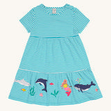 Frugi Pixy Sea Moss Mini Stripe Dress laid flat, with a Sealife print along the bottom, featuring whales, dolphins, sharks, a Mermaid and some small fish, surrounded by colorful seaweed.