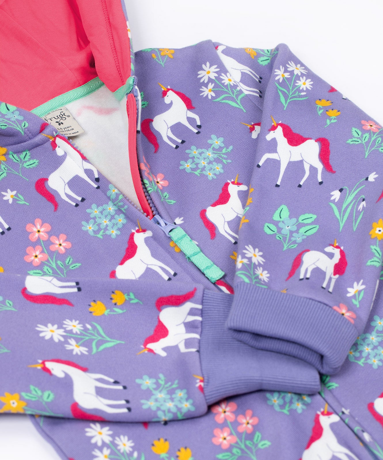 A close up of the zip closure on the front of the Frugi Organic Cotton purple unicorn floral print Children's Big Snuggle Suit. This all in one snuggle suit is a part of a wide range of organic cotton clothing for children available here at Babipur.