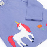A close up of the unicorn applique  on the front of the Frugi grape purple unicorn Organic Cotton Ottlie Outfit. An outfit with a purple coloured top with a unicorn applique on the front and pink unicorn print leggings. This outfit is a part of a wide range of organic cotton clothing for children available here at Babipur.