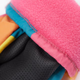A close up of the Frugi kids rainbow check snow mittens showing the black grippy palm and pink fleece inner for warmth