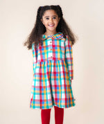 A child wearing the Frugi Rainbow Check Organic Cotton Ffion Dress. The dress has a rounded collar details and button closure on the front. This festive kids dress is a part of a wide range of organic cotton clothing for children available here at Babipur.