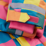 A close up of the Frugi kids snow and ski coat in rainbow check showing the pink storm cuff detail and reflective strips