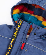 A close up of the Frugi kids 3 in 1 rambler coat in Autumn stripe /navy colourway showing the zip detail and striped fleece liner inner on the hood
