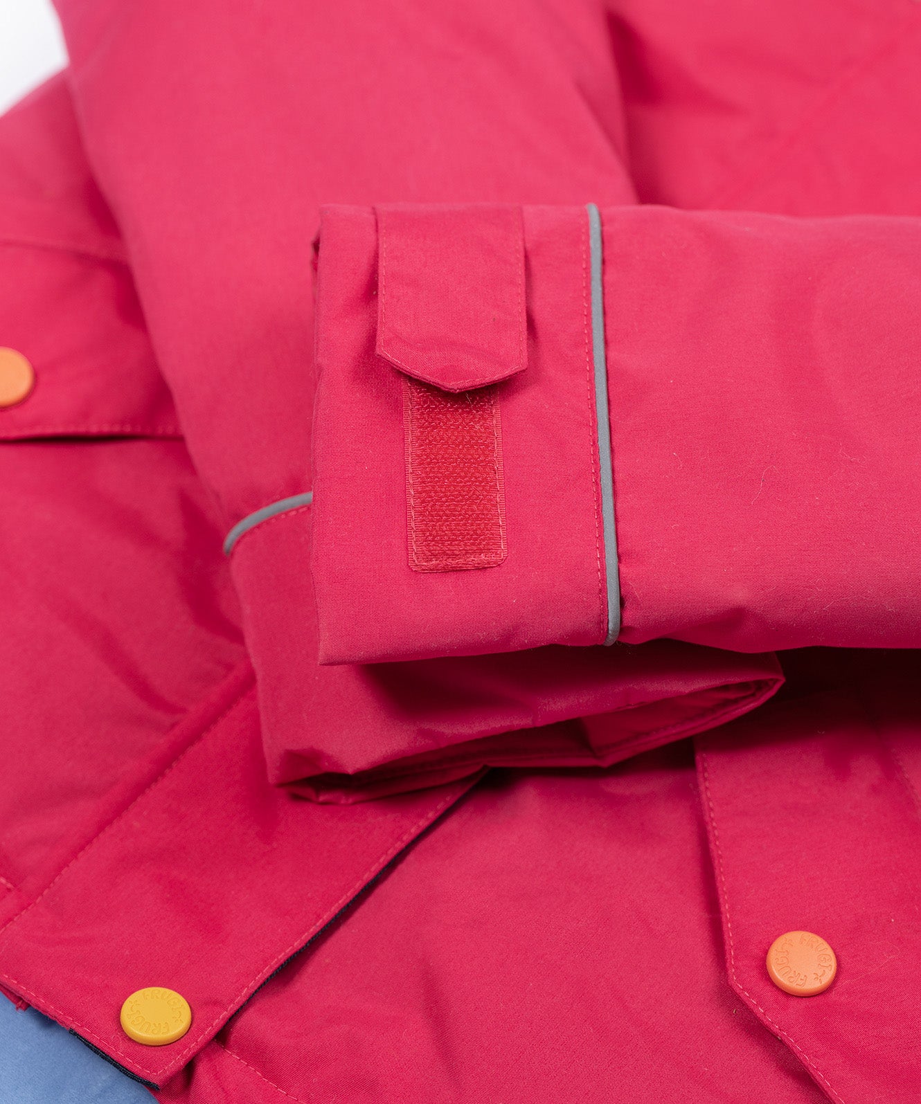 A close up of the Frugi kids 3 in 1 rambler coat in snapdragon /navy colourway showing the velcro detail on the arm for size adjusting.