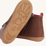 A view of the rubber soles on the Frugi Ravine easy on children's leather boots in a brown, wild woods design.