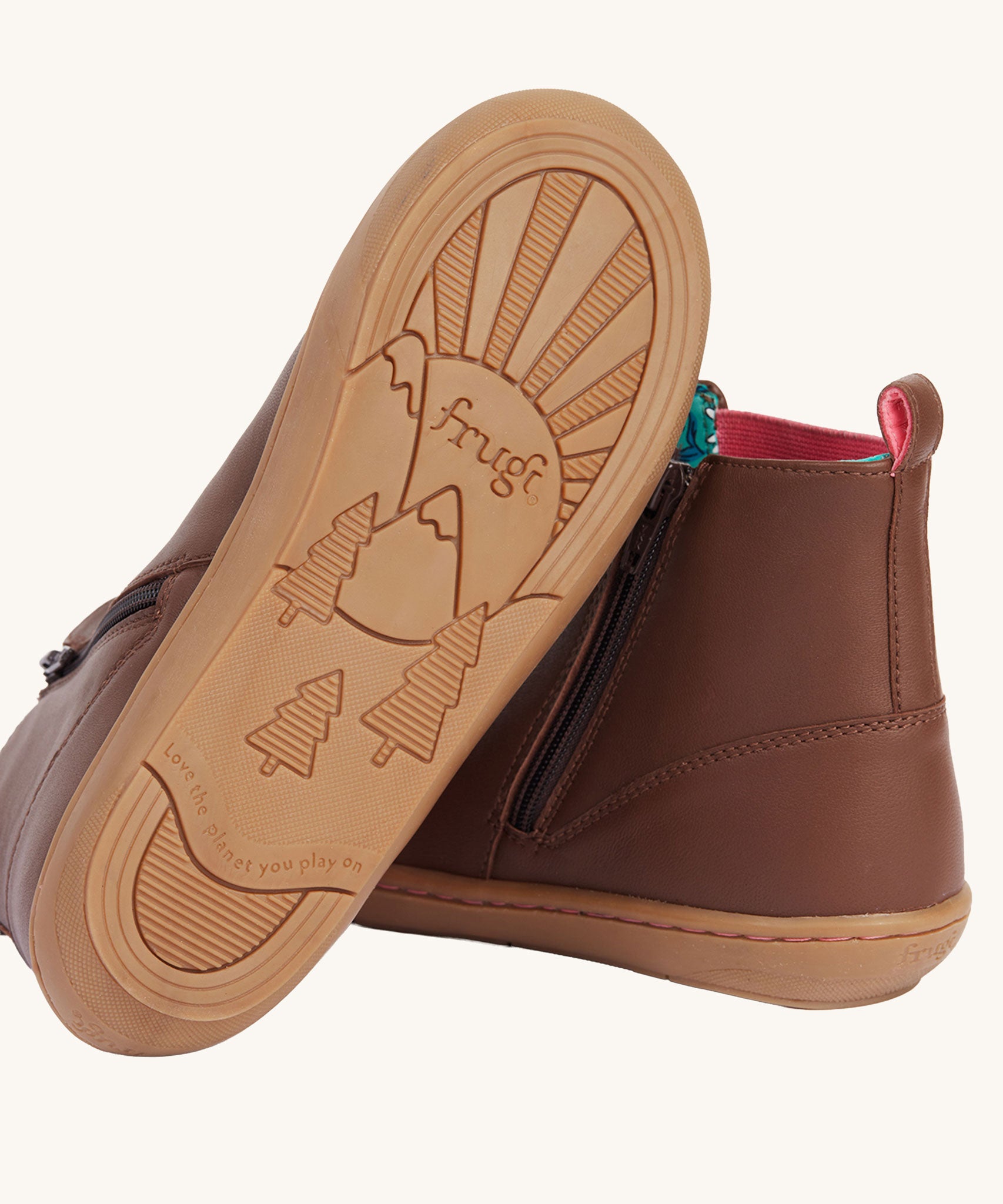 A view of the rubber soles on the Frugi Ravine easy on children's leather boots in a brown, wild woods design.