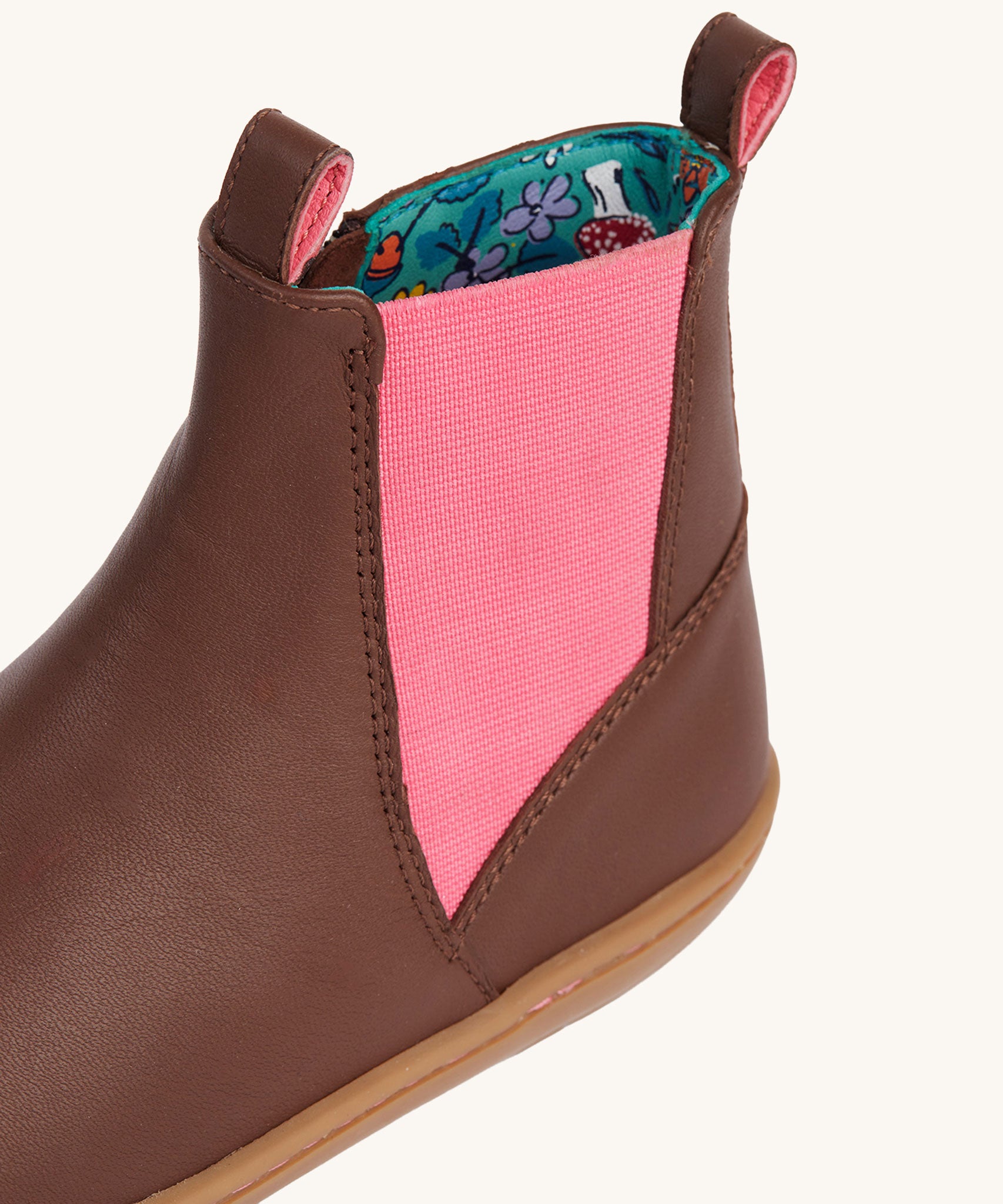 A close up of the pink panel on the sides of the Frugi Ravine easy on children's leather boots in a brown, wild woods design.