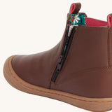A close up of the zip on the side of the Frugi Ravine easy on children's leather boots in a brown, wild woods design.