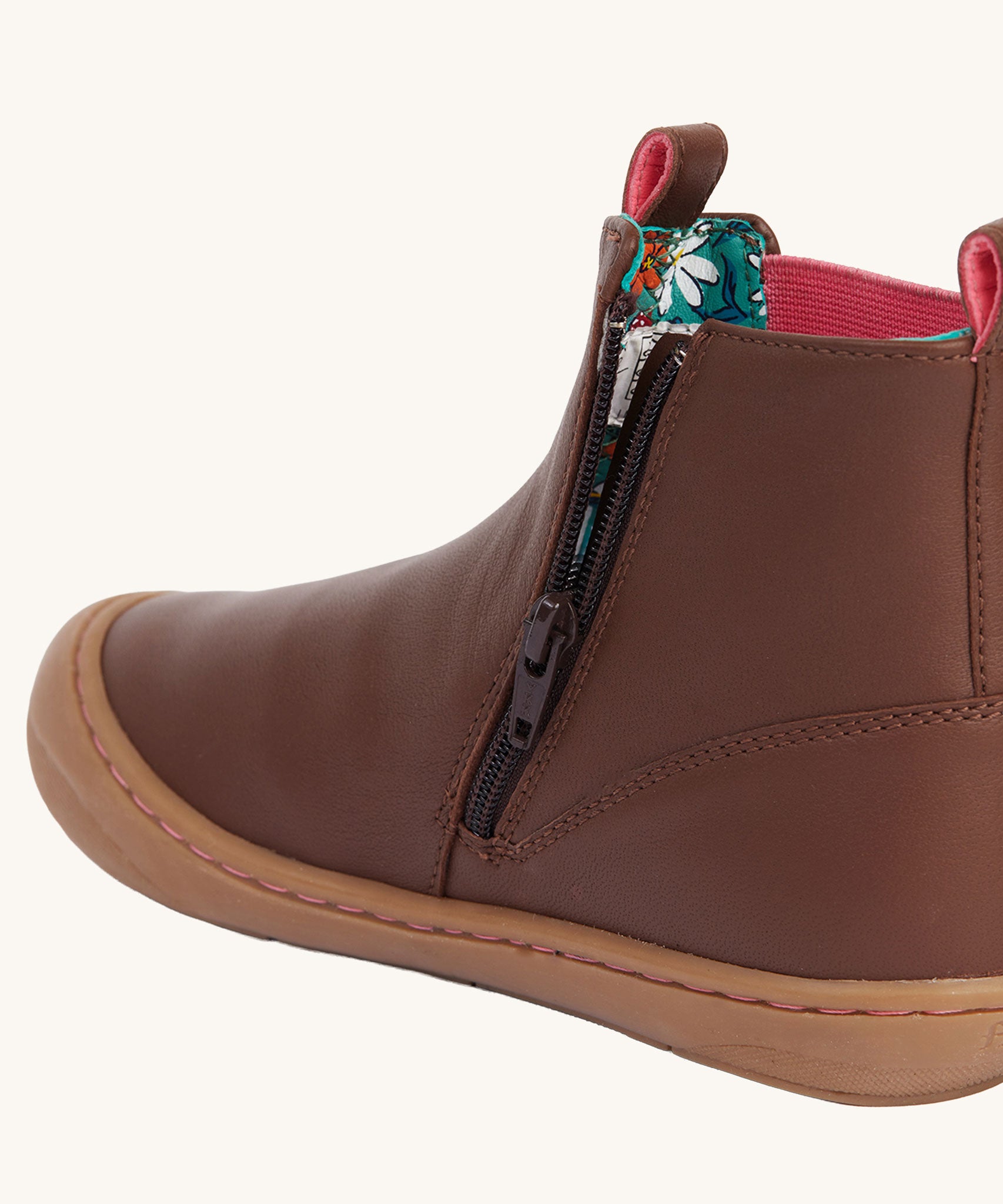 A close up of the zip on the side of the Frugi Ravine easy on children's leather boots in a brown, wild woods design.
