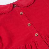 A close up of the button closure on the back of the Frugi Red Robin Corduroy Kids' Christmas Organic Dress. This red cord dress is a part of a wide range of organic cotton clothing for children available here at Babipur.